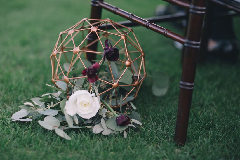winter wedding aisle marker with gold geometric sphere, burgundy flowers and greenery