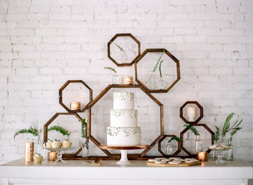 modern bohemian wedding dessert display with geometric wooden octagon backdrop and greenery