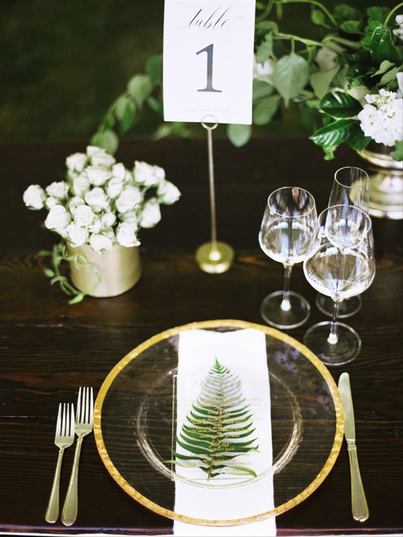 woodland wedding idea — fern leaf and menu card at gold and white place setting 