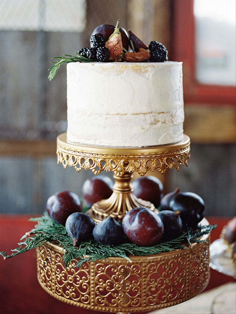 moody white buttercream wedding cake decorated with plums and figs