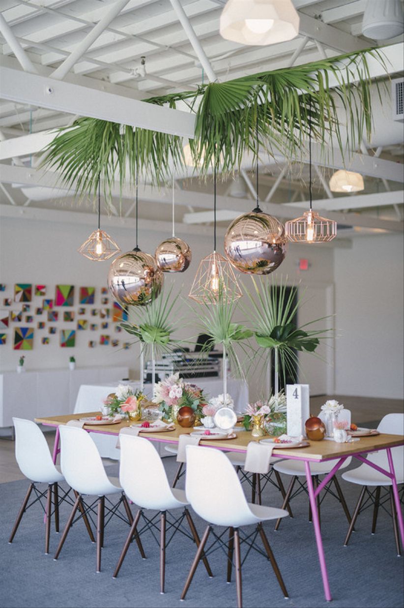 colorful Palm Springs wedding idea — modern wood table with bright pink and green centerpieces and geometric copper lighting fixtures